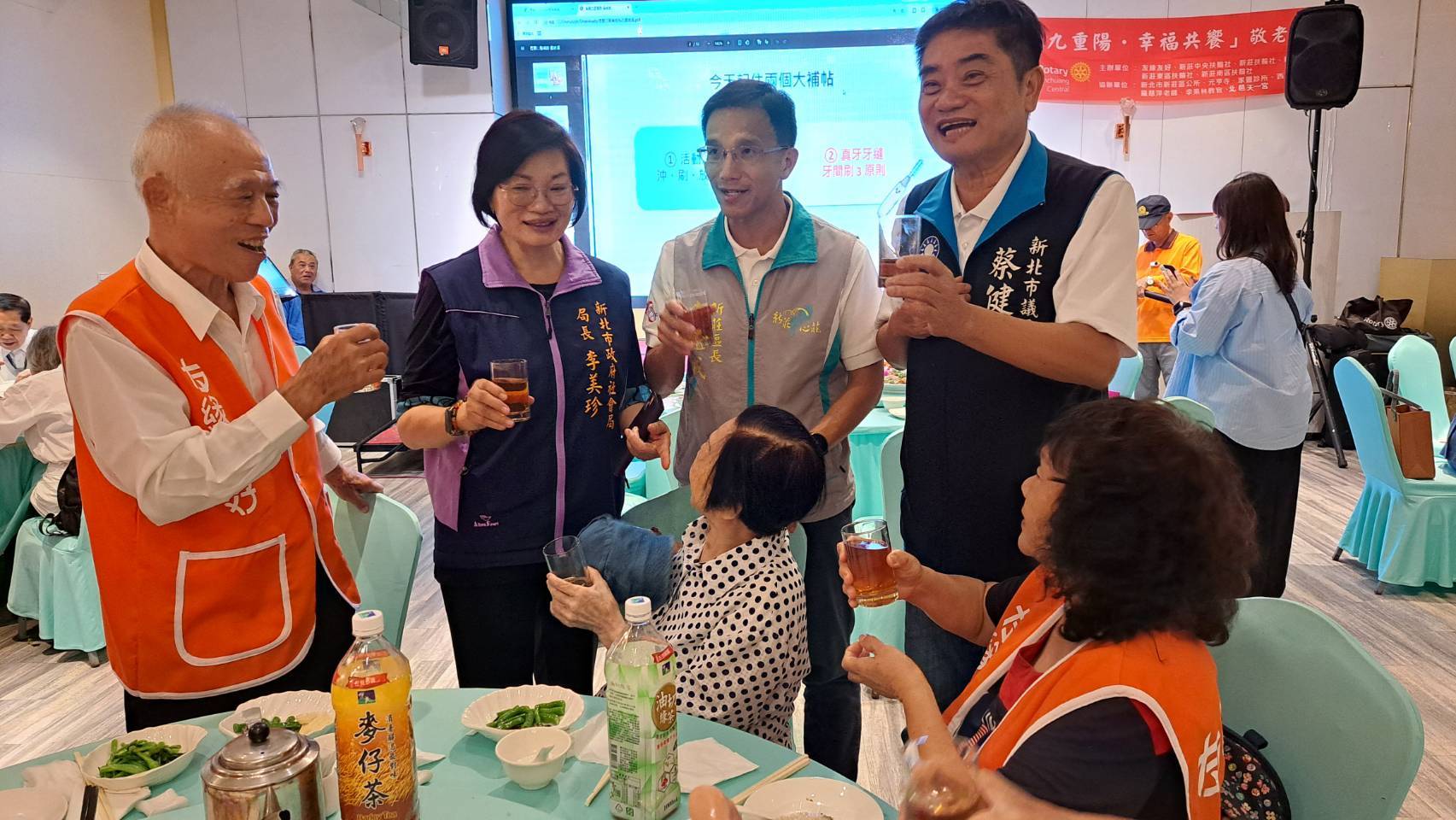  社會局長李美珍和新莊區長朱思戎.議員蔡健棠一起向參加重陽敬老餐會的長輩致意。