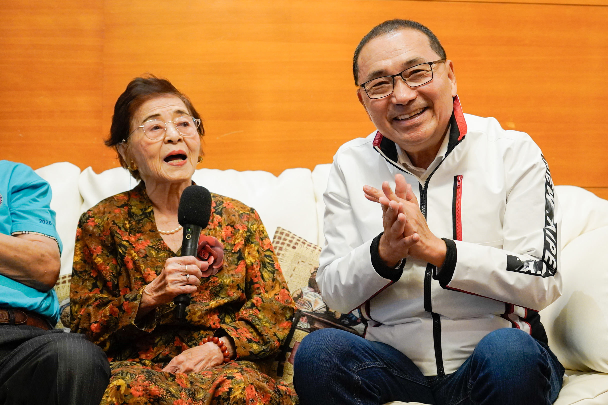  洪許俸清唱「桃太郎」兒歌，侯友宜在一旁幫忙打拍子。
