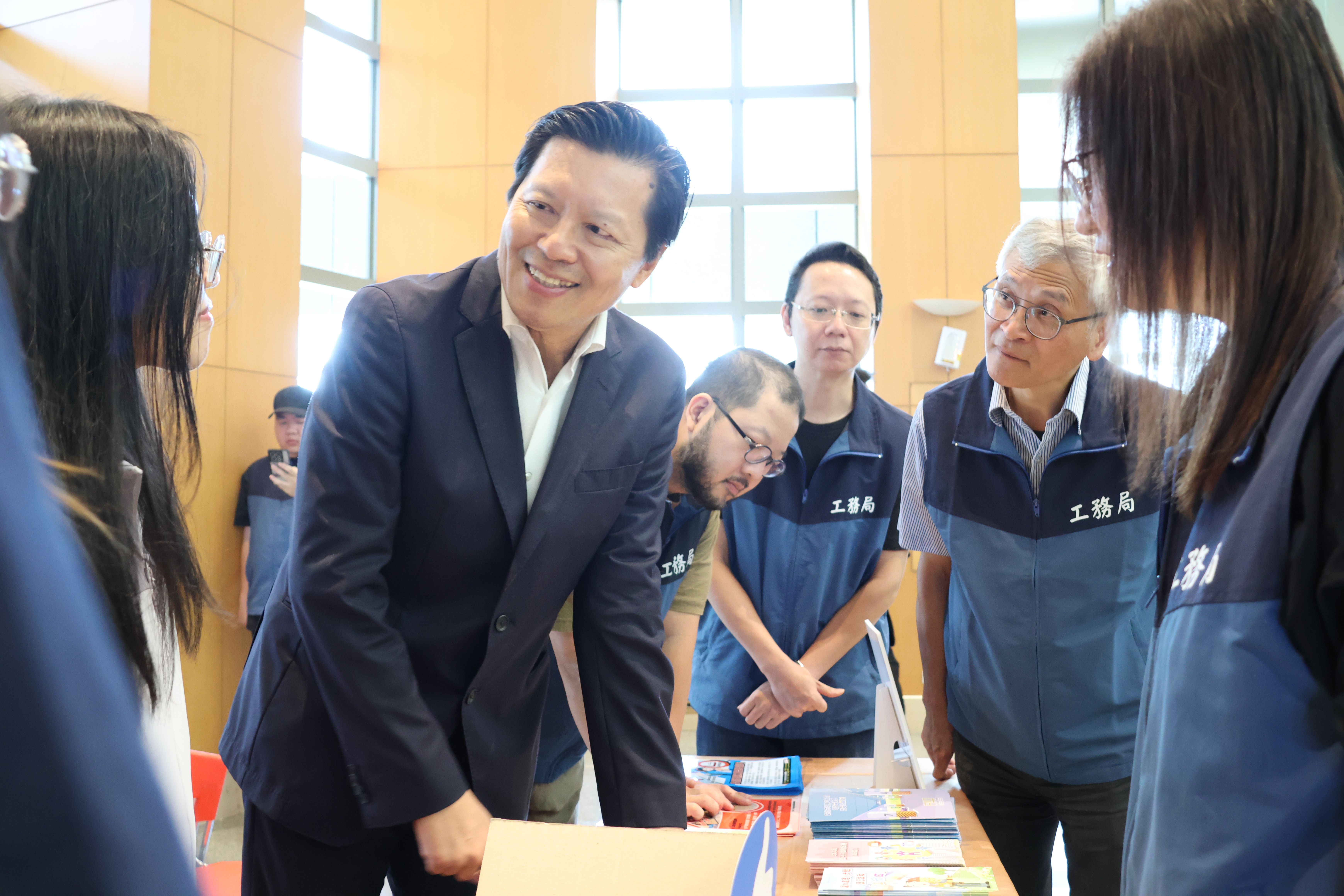 朱惕之副市長(左二)與工務局副局長林炳勲(左五)逐一巡視得獎社區的攤位。