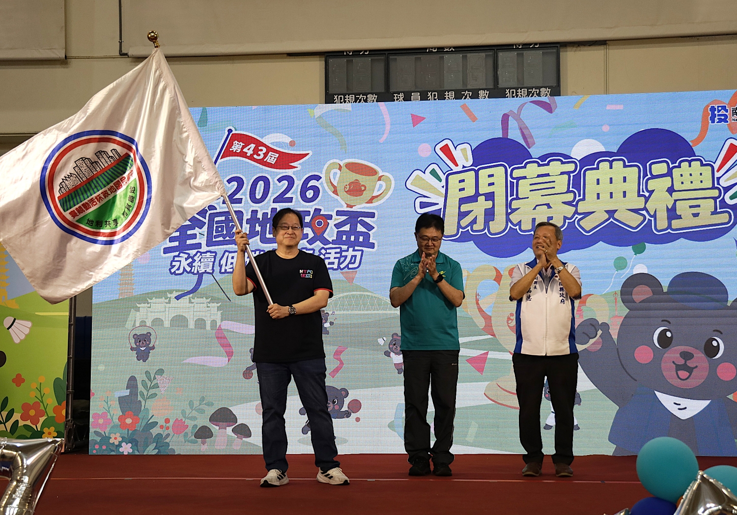 新北市副秘書長林豐裕(左)接下會旗，接手舉辦2027全國地政盃賽事。新北市地政局提供