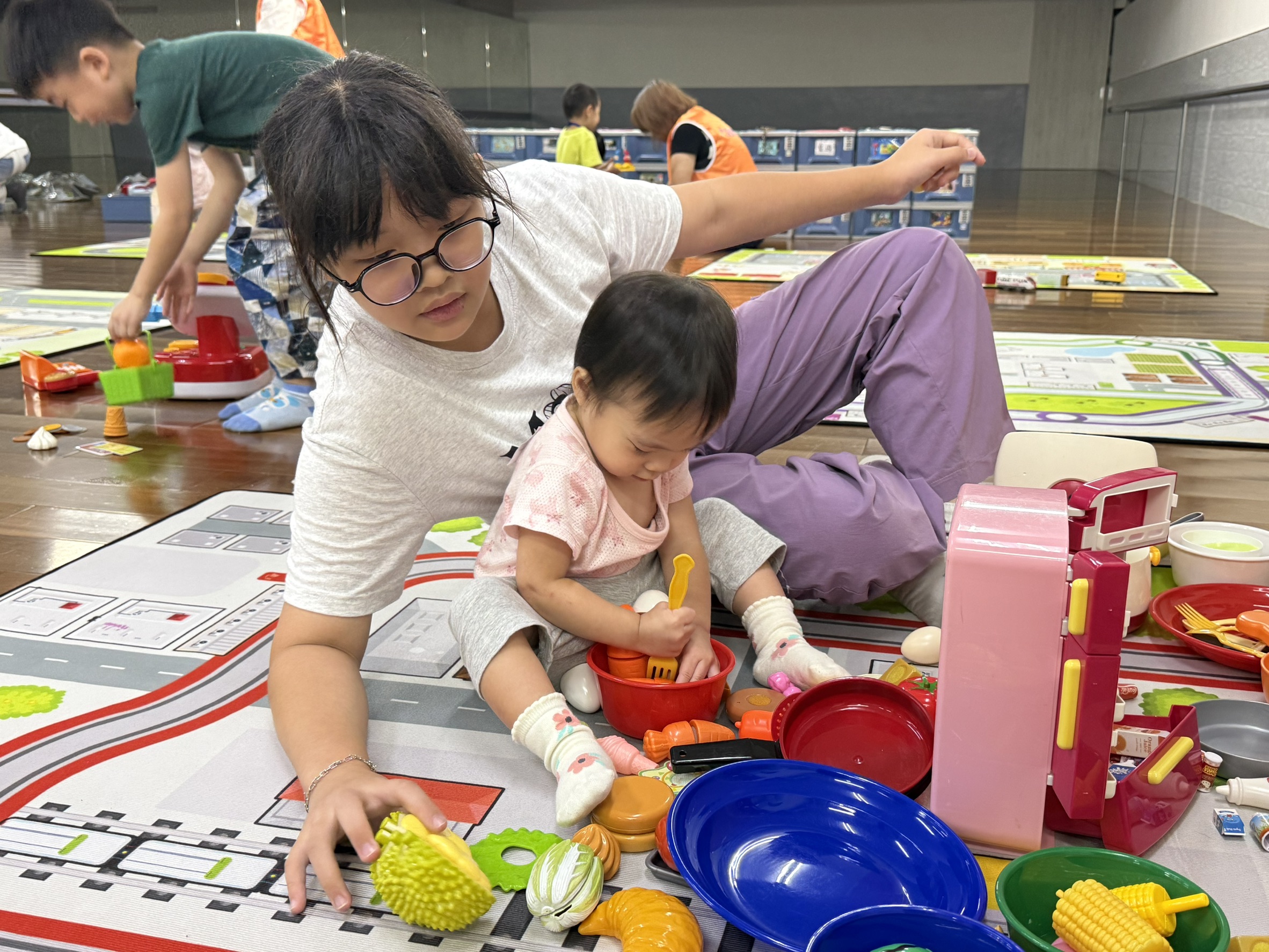  家長帶著孩子參加親職活動，並透過遊戲和玩具觀察孩子的發展。