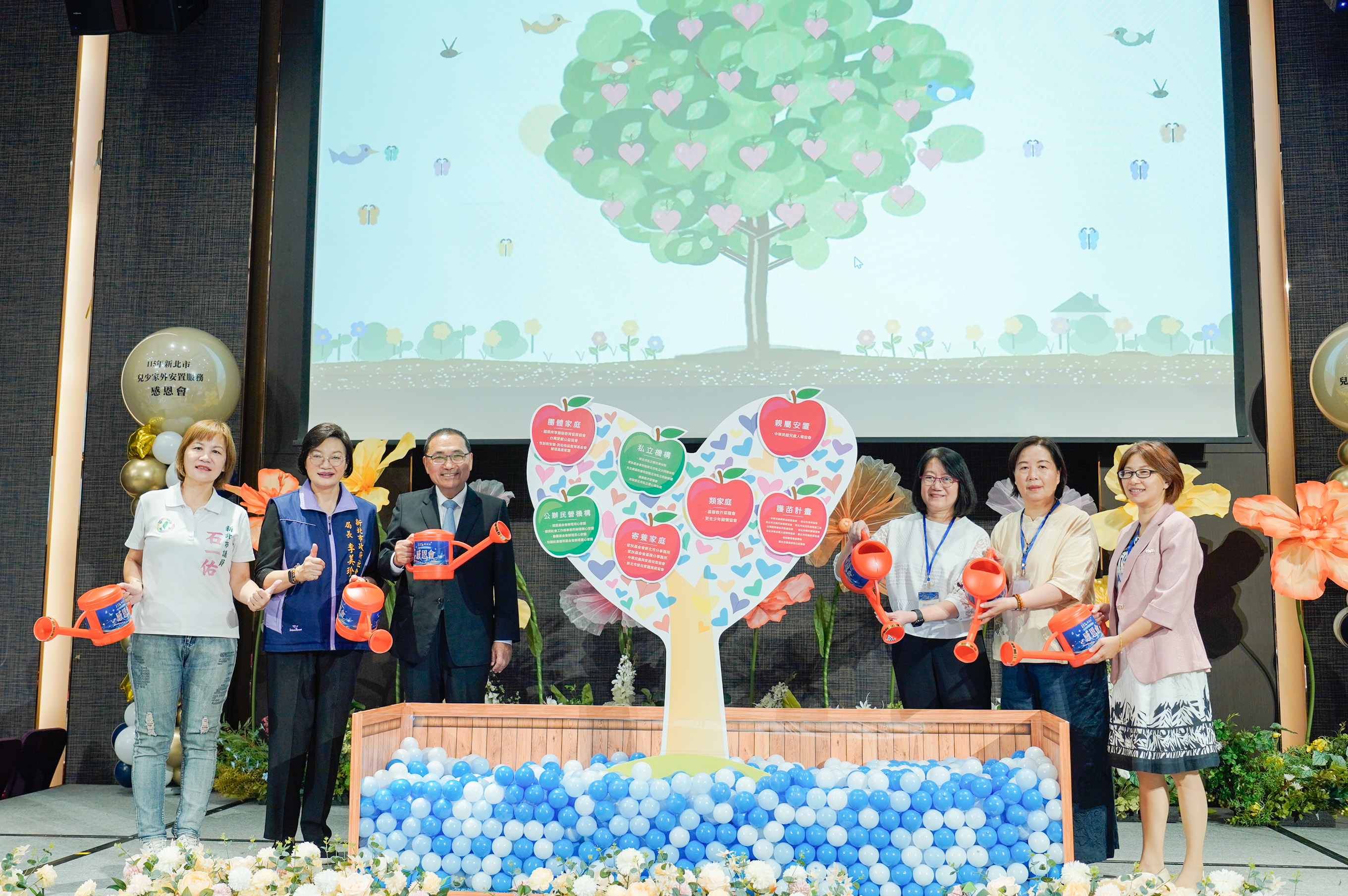  侯友宜市長、李美珍局長和中華兒童與家庭促進協會理事長梅心潔（右起）、寄養家庭徐季幼及愛心育幼院院長蘇鈺惠等一起象徵用愛灌溉幼苗
