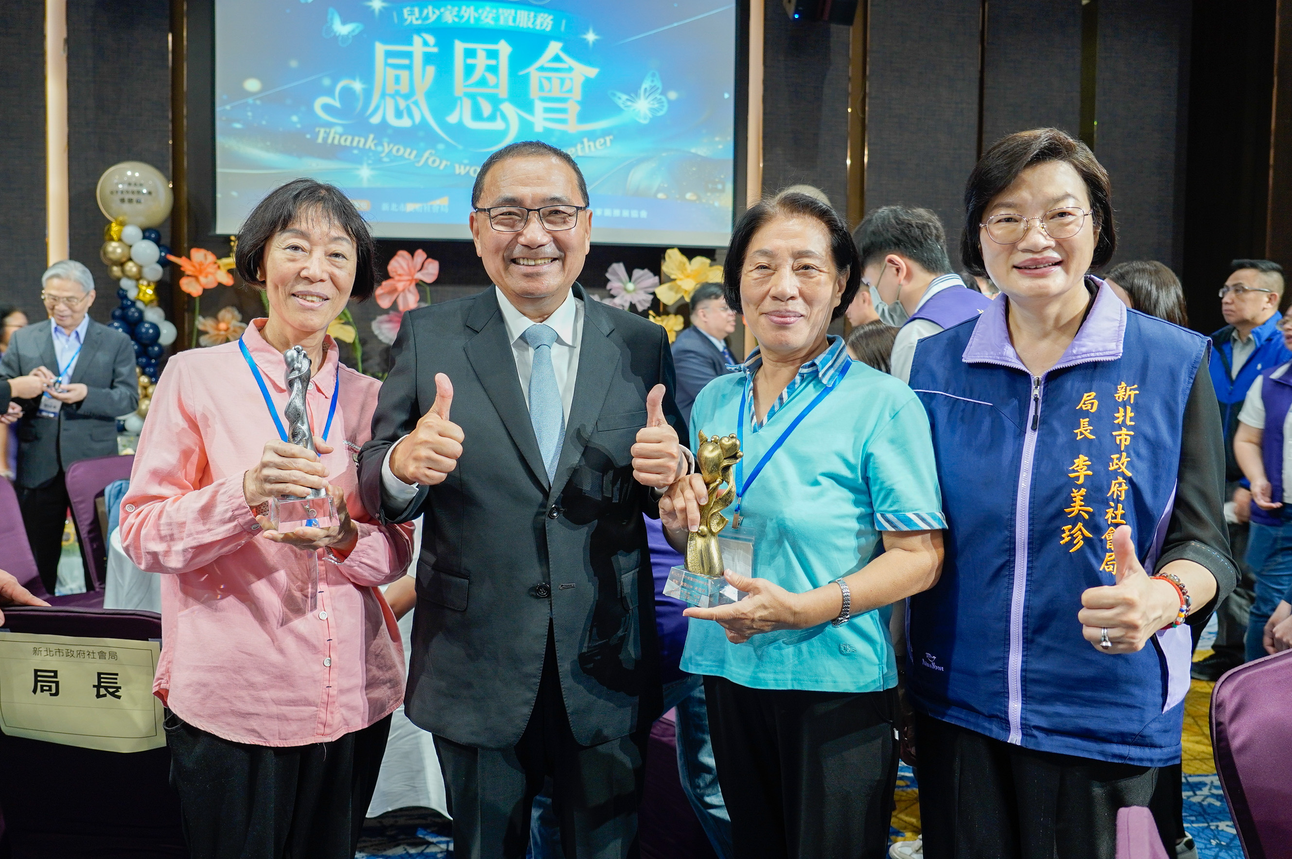  馬安琪（左1）、馬安娜（右2）兩姊妹合計照顧超過百位兒少，侯友宜和李美珍局長特別合影感念。