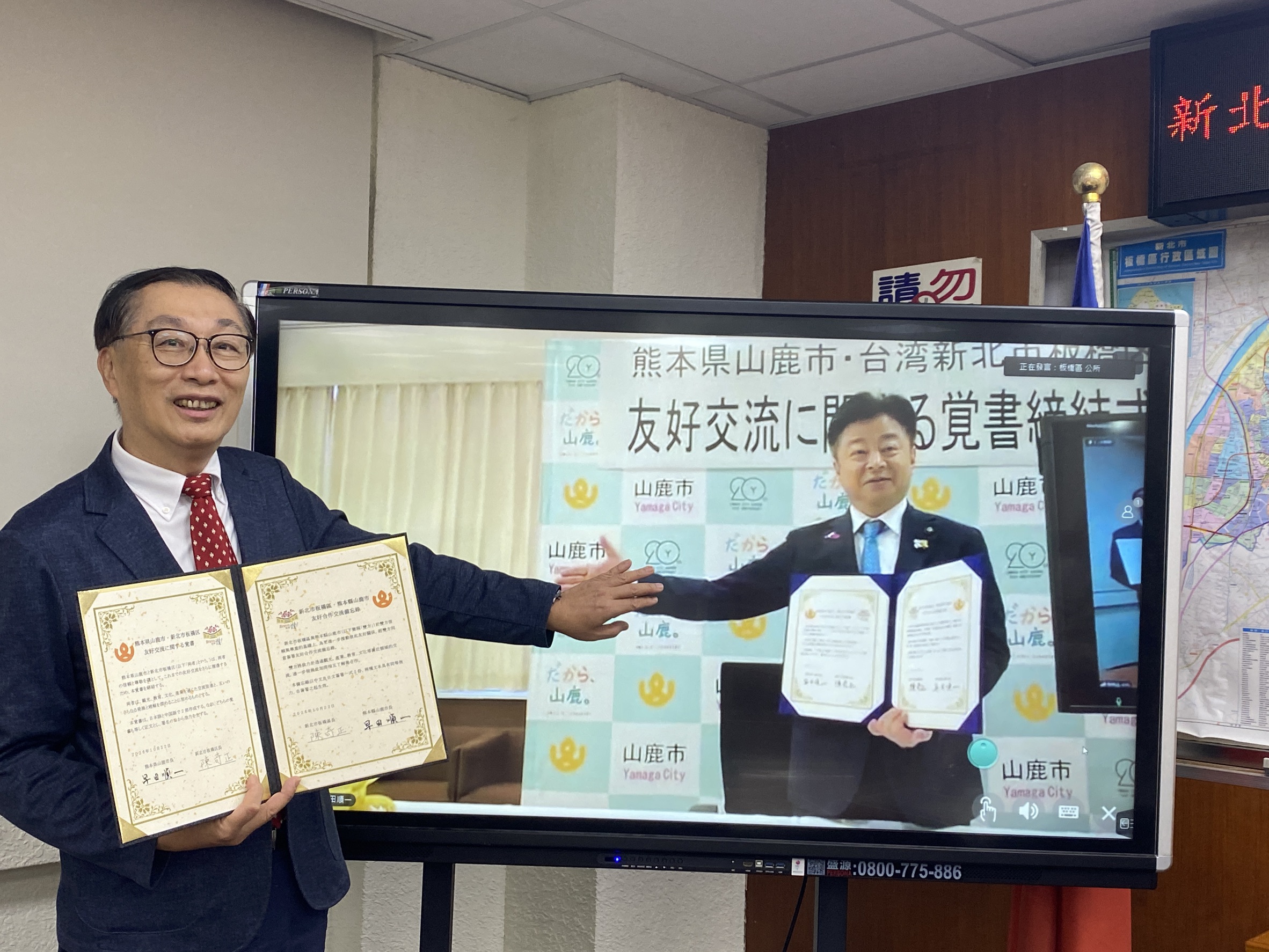1.板橋區陳奇正區長(左)與熊本縣山鹿市早田順一市長(右)，於視訊螢幕前擊掌合影