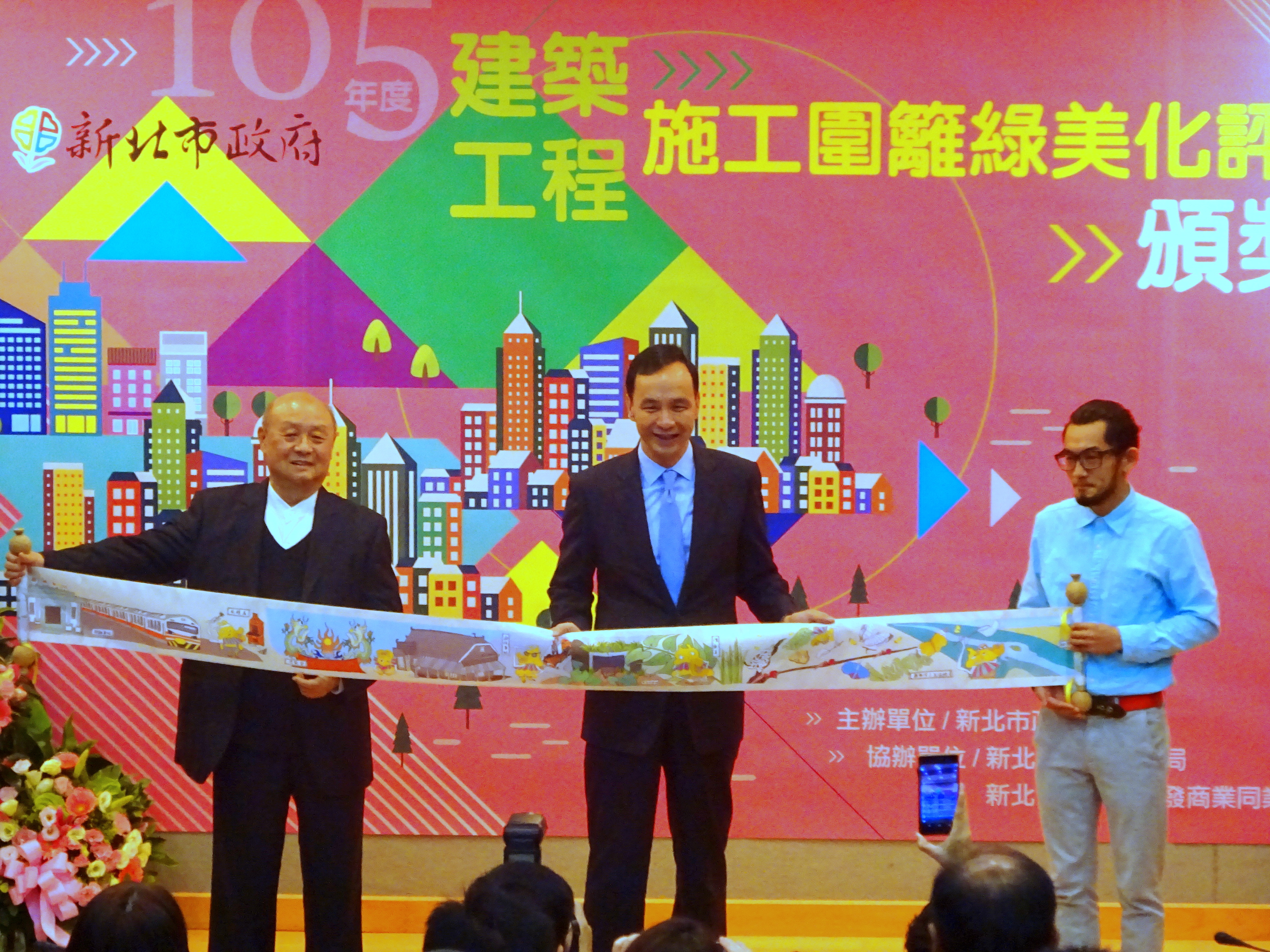 中華工程董事長嚴雋泰與藝術家彼得先生將施工圍籬彩繪製成捲軸布條送給市長