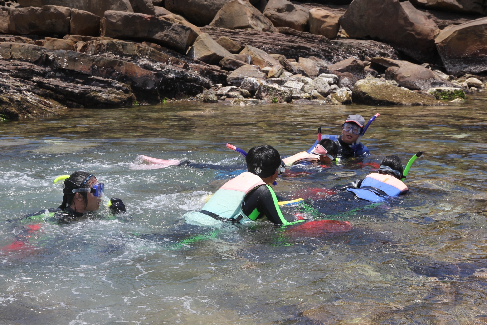 每年畢業生泳渡卯澳灣的活動，是福連國小畢業典禮的重頭戲。橘色袋子裝著九孔幼貝