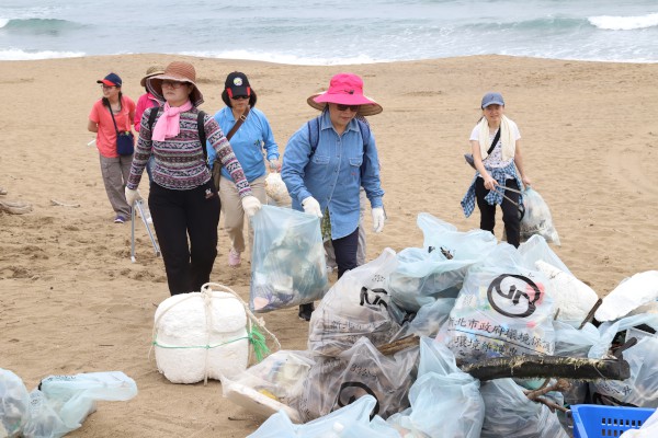 環保志義工與在地居民們一起清理沙灘垃圾，共同維護海岸環境