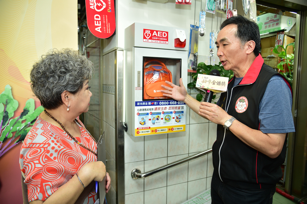 泰山市場總幹事李昌明向鳥來嬤介紹市場內的銀髮友善設施