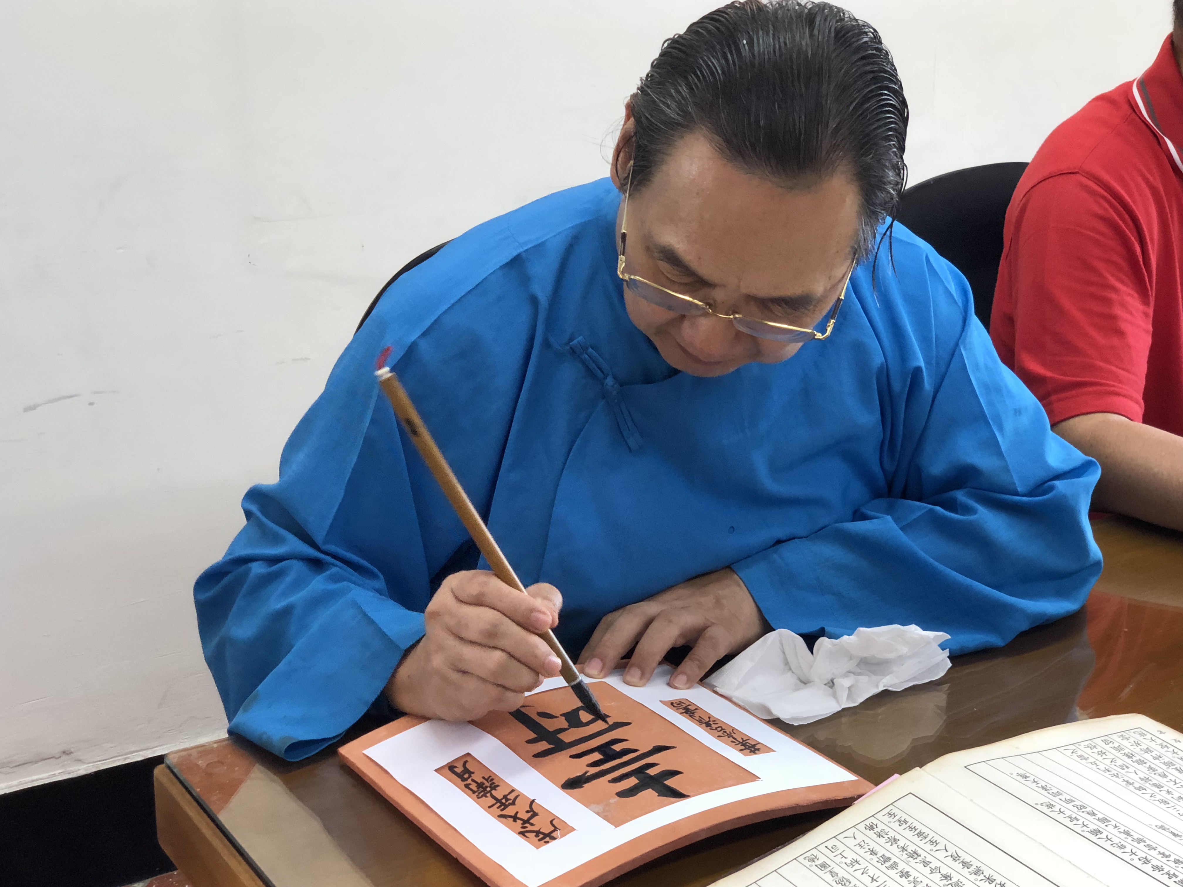 智成堂舉辦千人寫壽字活動，民眾在紅瓦片寫上不同字體的壽字