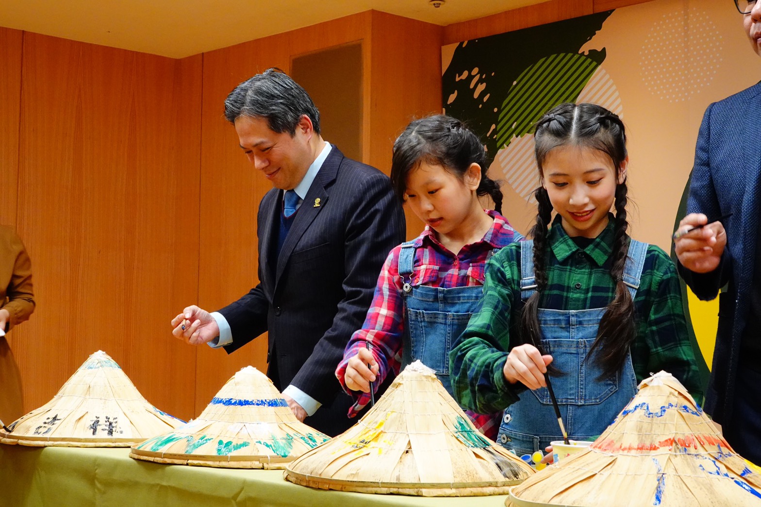吳明機副市長與孩童一起彩繪斗笠