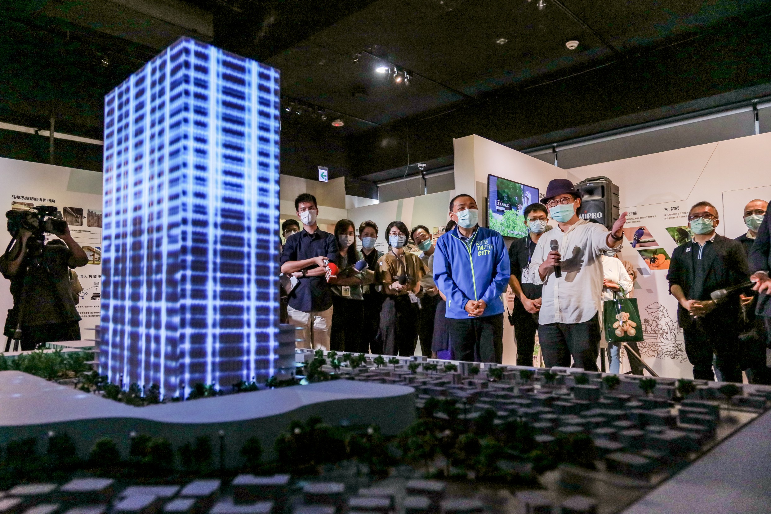 台北科技大學工業設計系江振維教授為侯市長介紹和學生們一起設計的三重第二行政中心光雕秀概念與意涵
