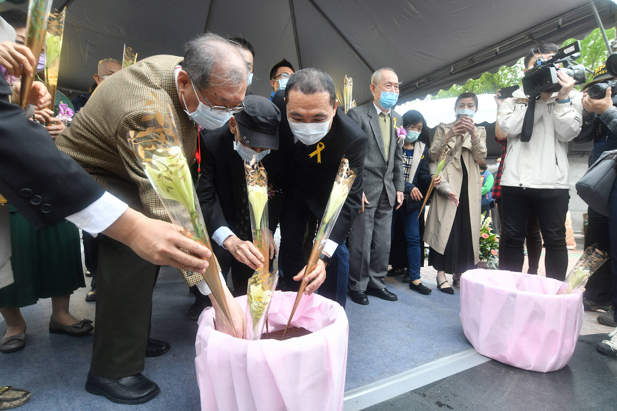 侯市長和與會者默哀後，手執鮮花走到紀念碑前獻花。