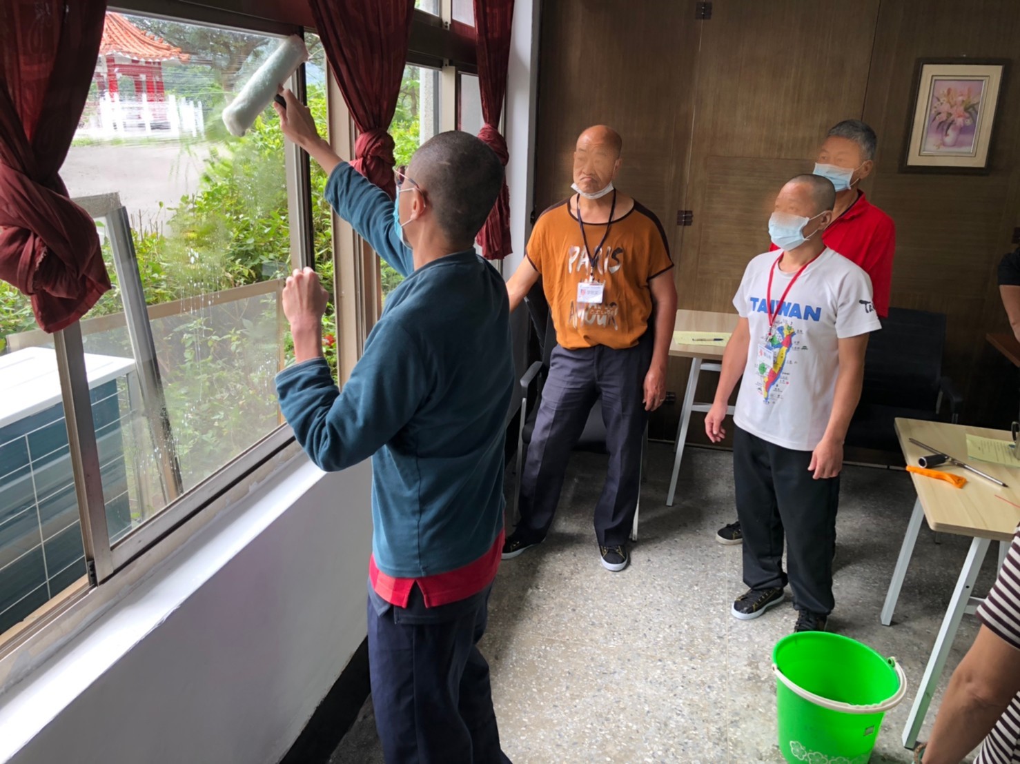 參加家事清潔服務培訓班的街友操作清潔窗戶玻璃