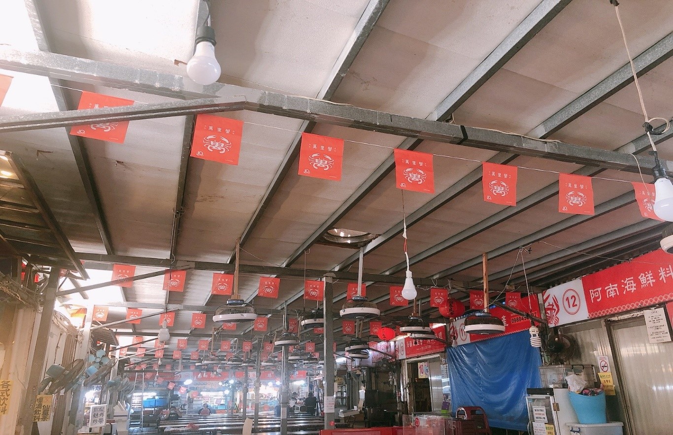 圖三：龜吼漁港用餐區上方懸掛小型萬字旗，在萬里蟹時節中旗幟下用餐更有風味
