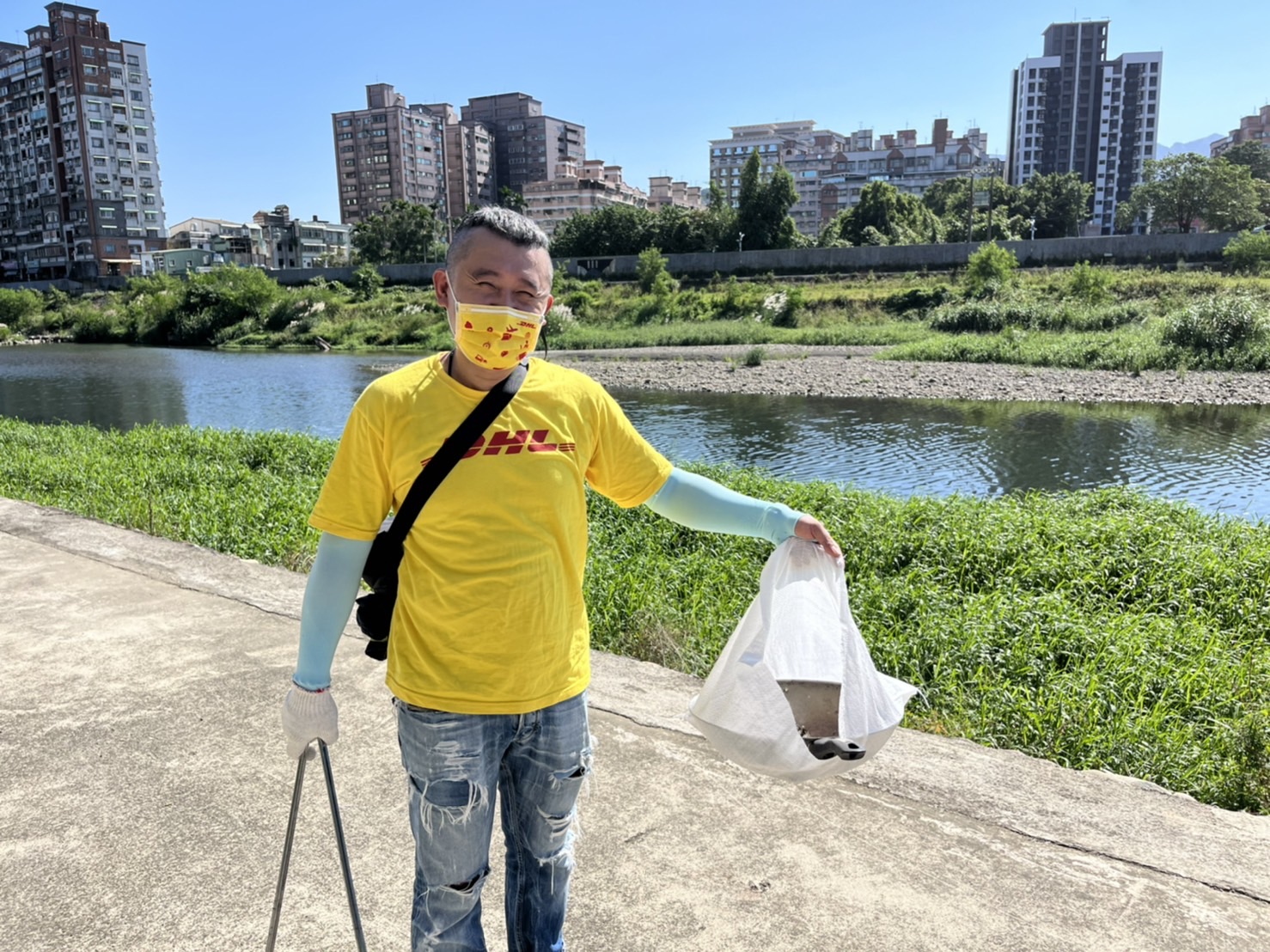 DHL國際快遞公司企業志工黃柏鈞意外的在河岸撿到任意丟棄的炒菜鍋