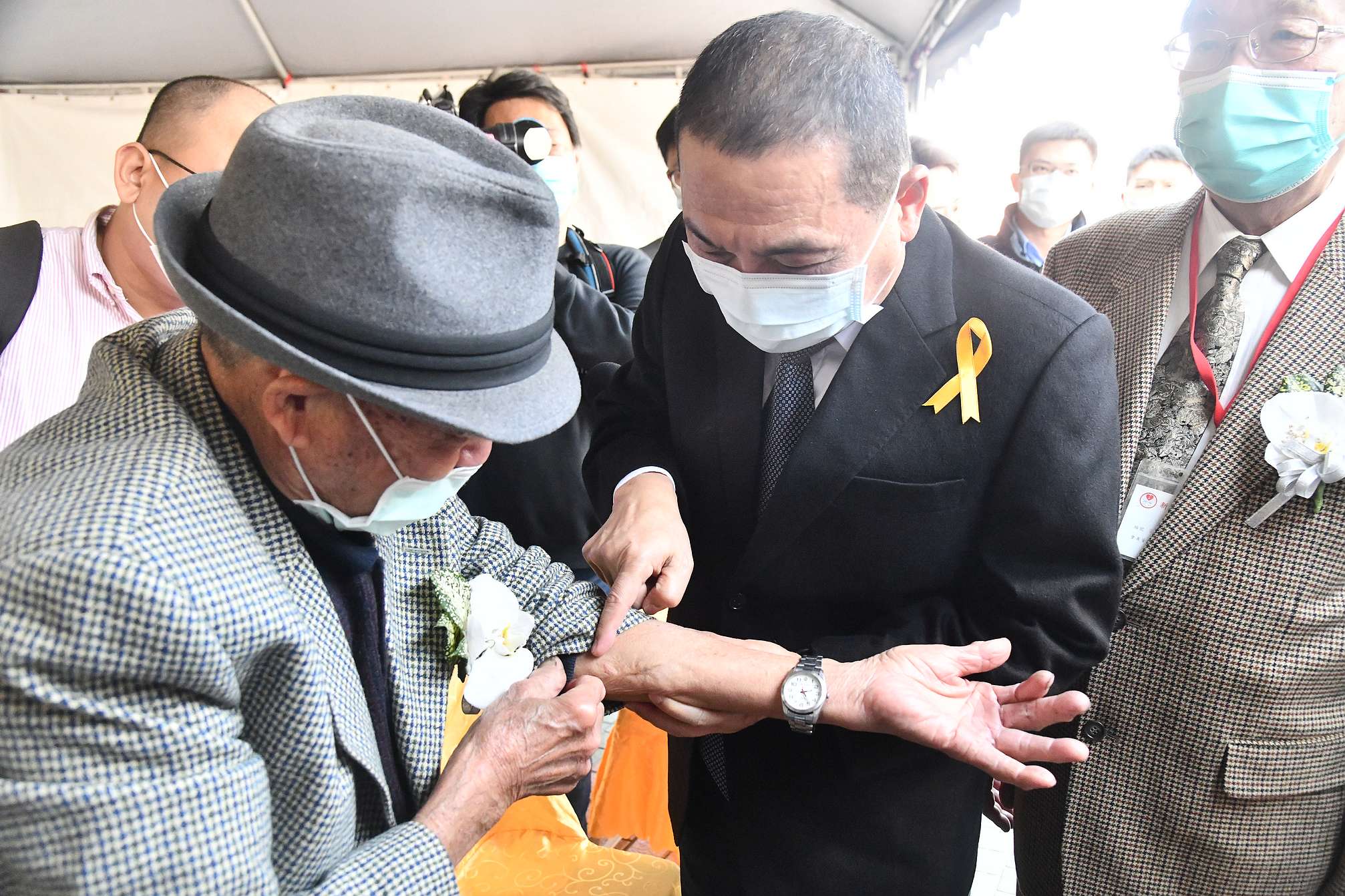 受難者趙水濱在會前向侯友宜展示當年被子彈擊中的傷疤