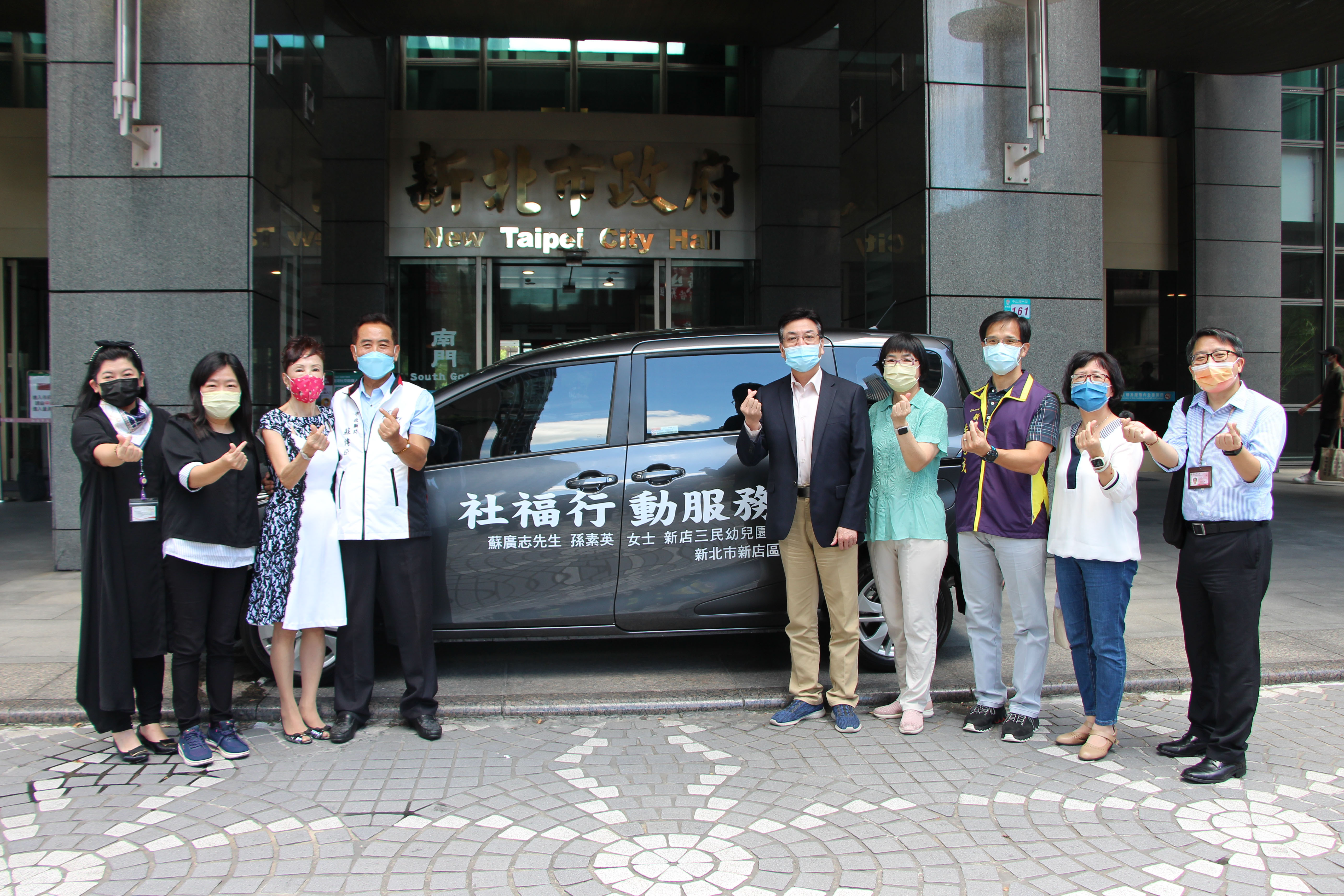 蘇傳臣夫婦（左4、3）以紀念雙親蘇廣志和孫素英名義捐贈社福專車給新店區公所   由副市長劉和然（右5）等人代收