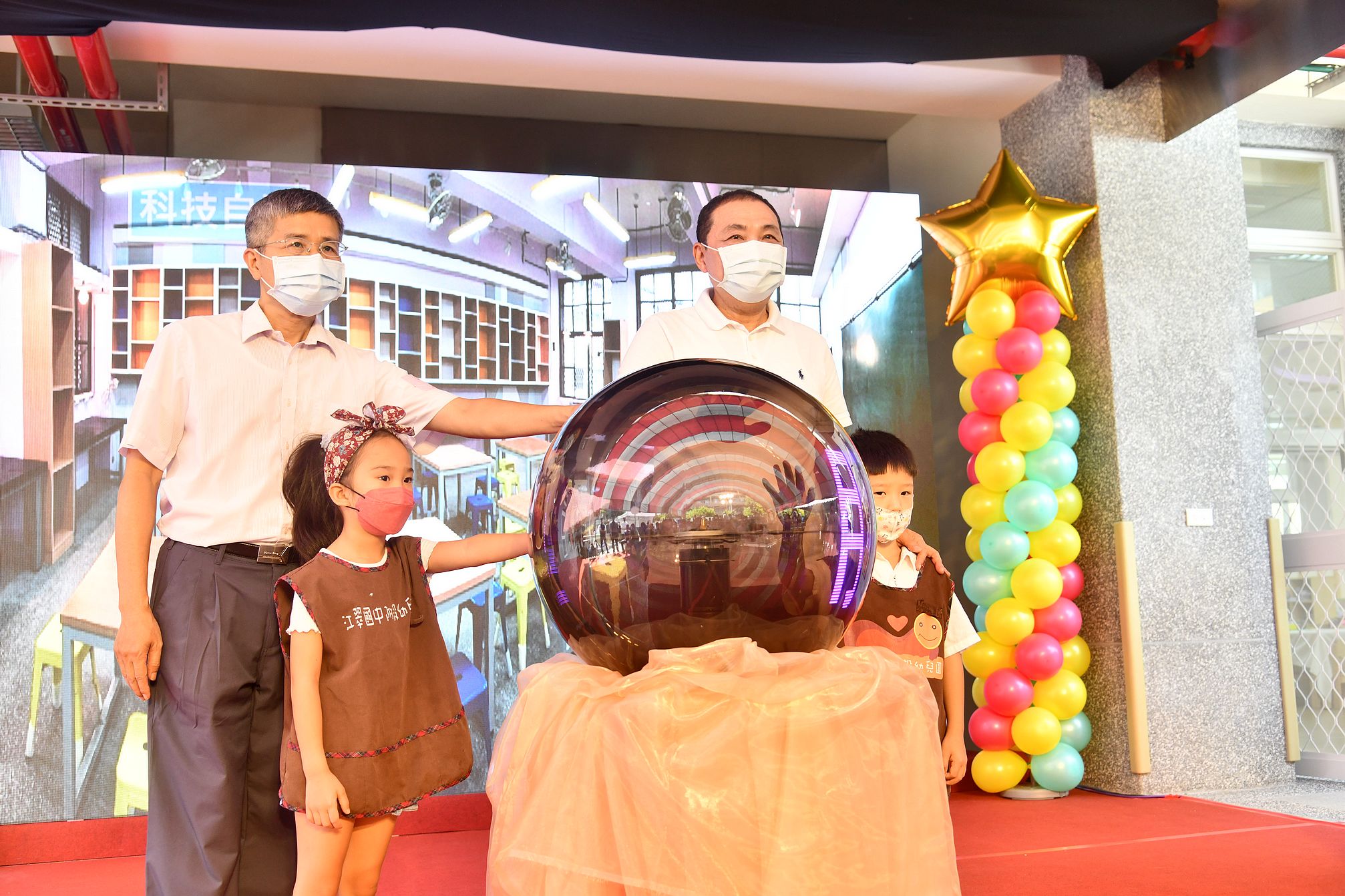 新北市長侯友宜今(15)日與幼兒園小朋友在江翠國中校舍啟用典禮中一起觸摸時光球宣布正式啟用。