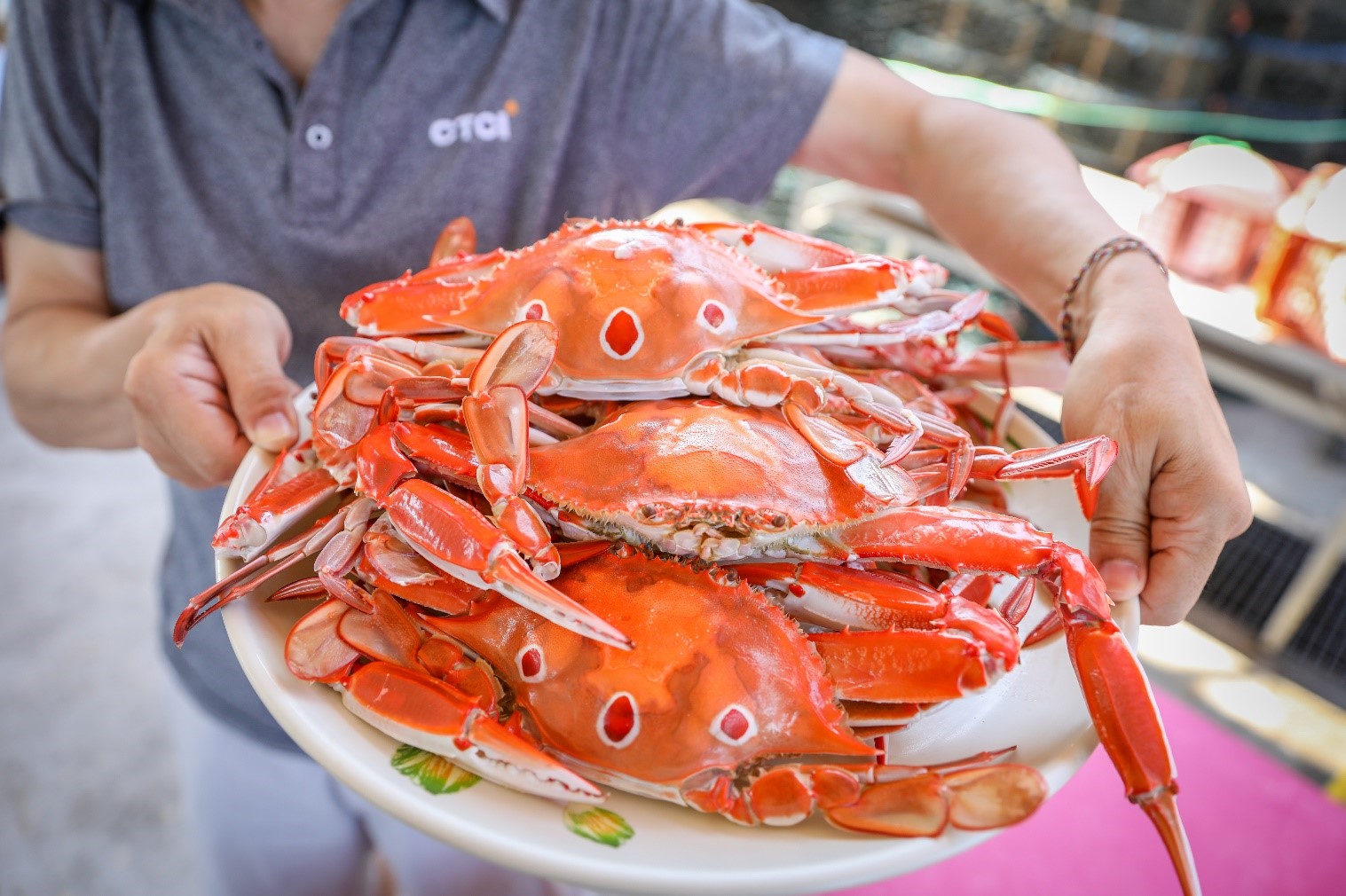 三點蟹產量為三種蟹中最大，價格親民受到饕客喜愛，圖中為民眾手持餐盤盛裝蒸熟後三點蟹。