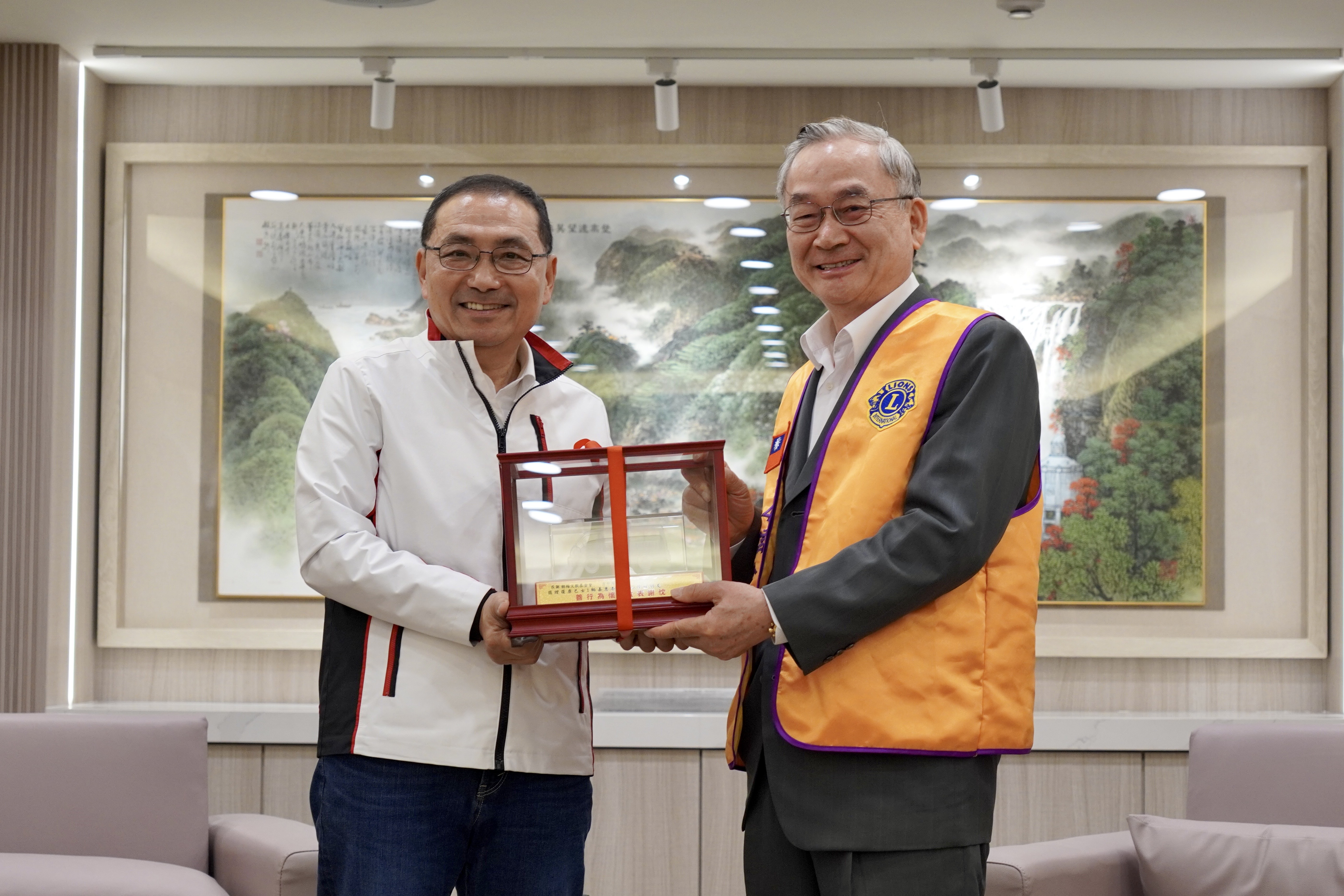 台北市民生獅子會長方仲海(右)捐贈第五輛復康巴士給新北市，由市長侯友宜代表受贈並表示感謝。