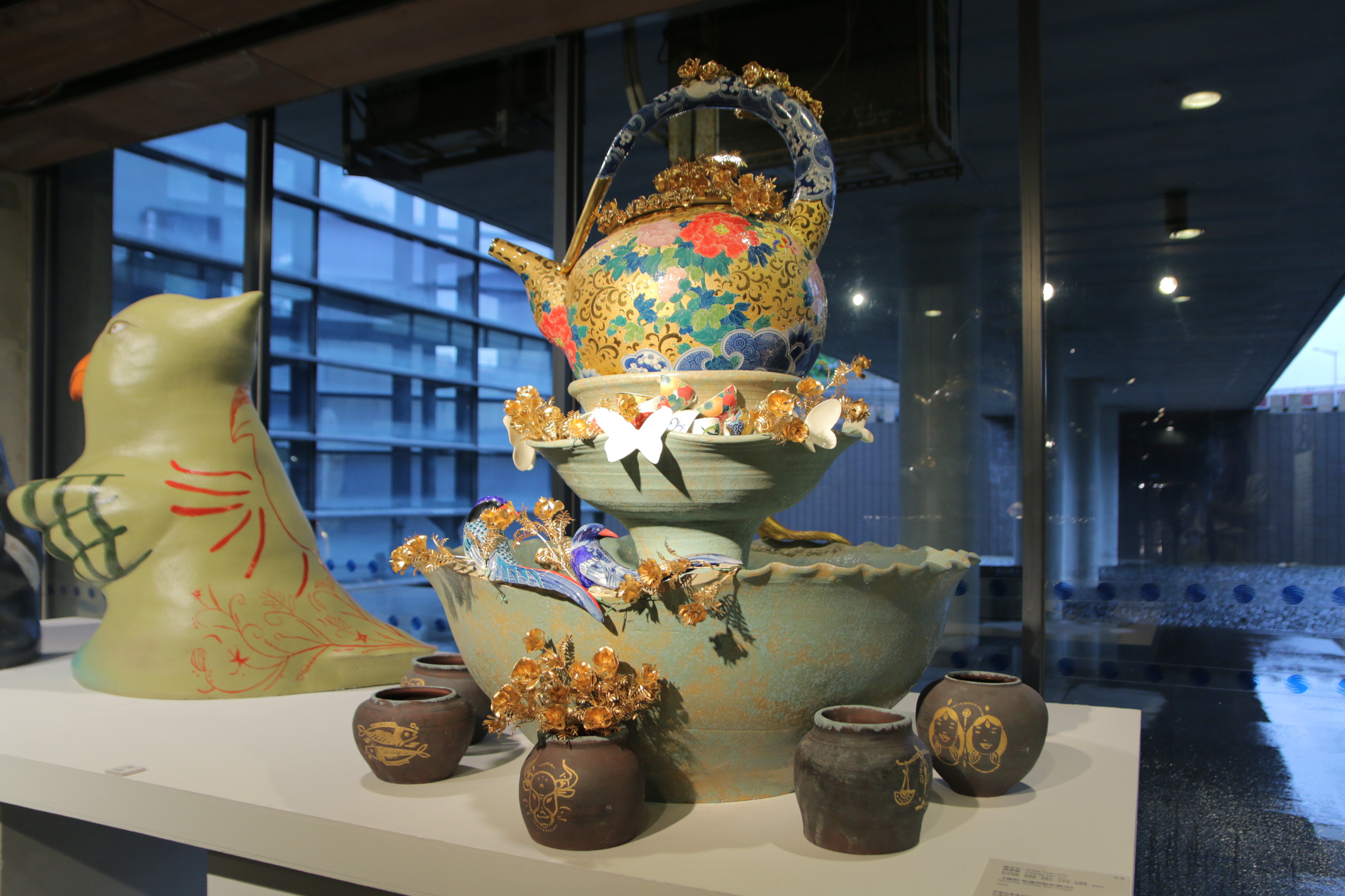 《福到—彩繪拼貼許願池》許願池上方裝置象徵「福氣」的華麗陶壺，四周裝置12星座的彩繪陶罐，營造幸福噴泉的氛圍。