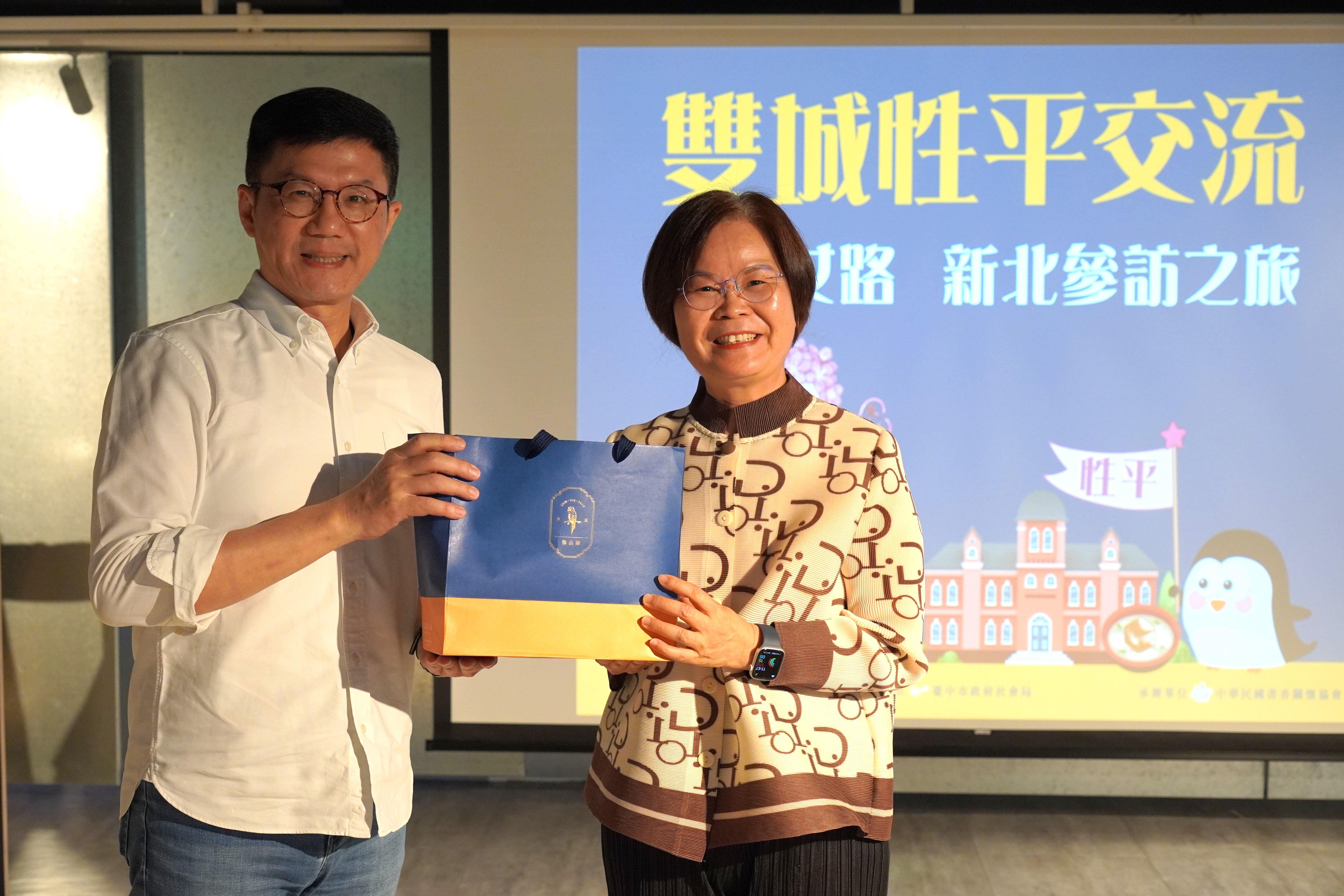 新北市政府副秘書長張其強(左)與台中市政府參事林月棗(右)互贈伴手禮。
