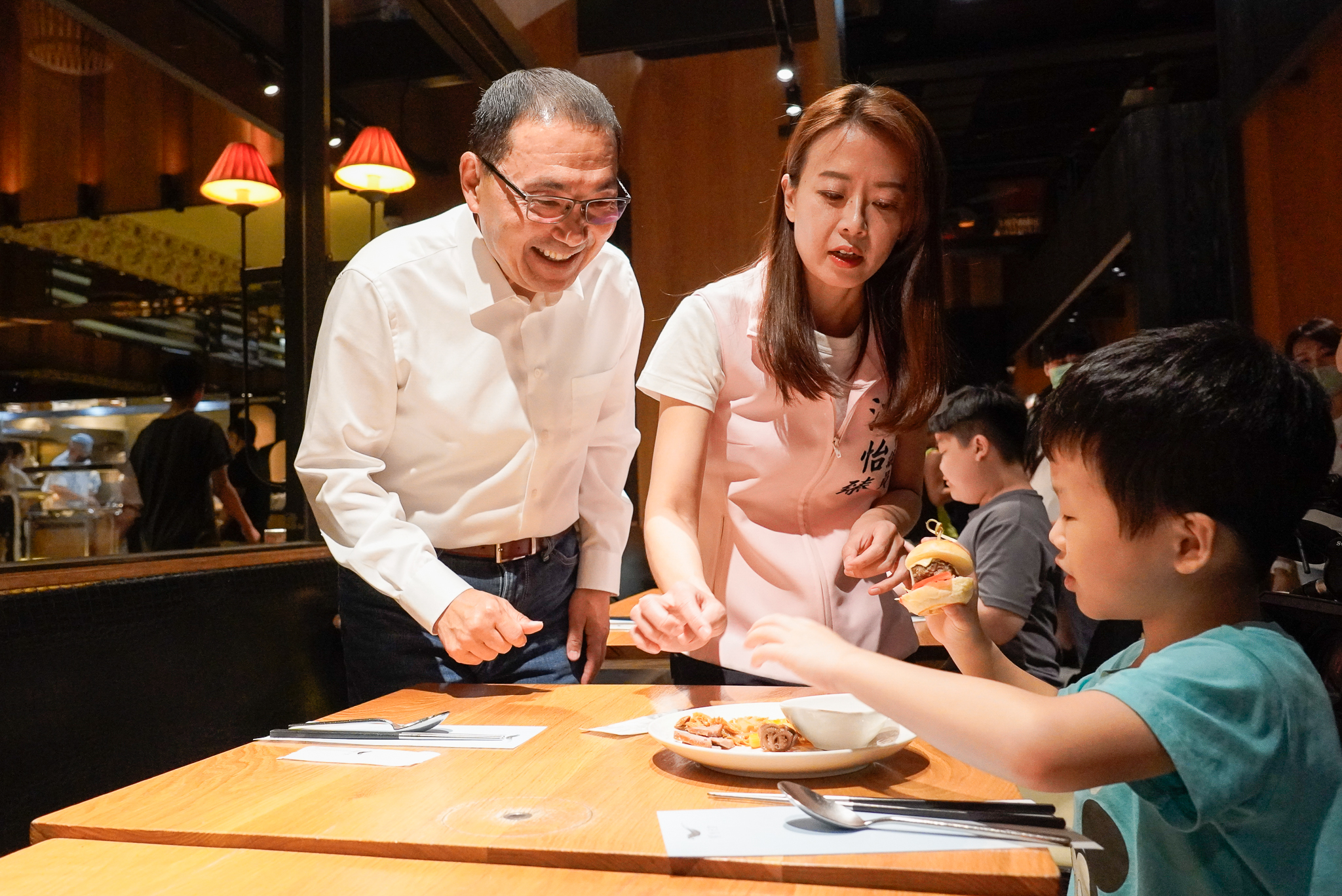 小朋友開心地和市長侯友宜、江怡臻議員分享自己夾了哪些食物