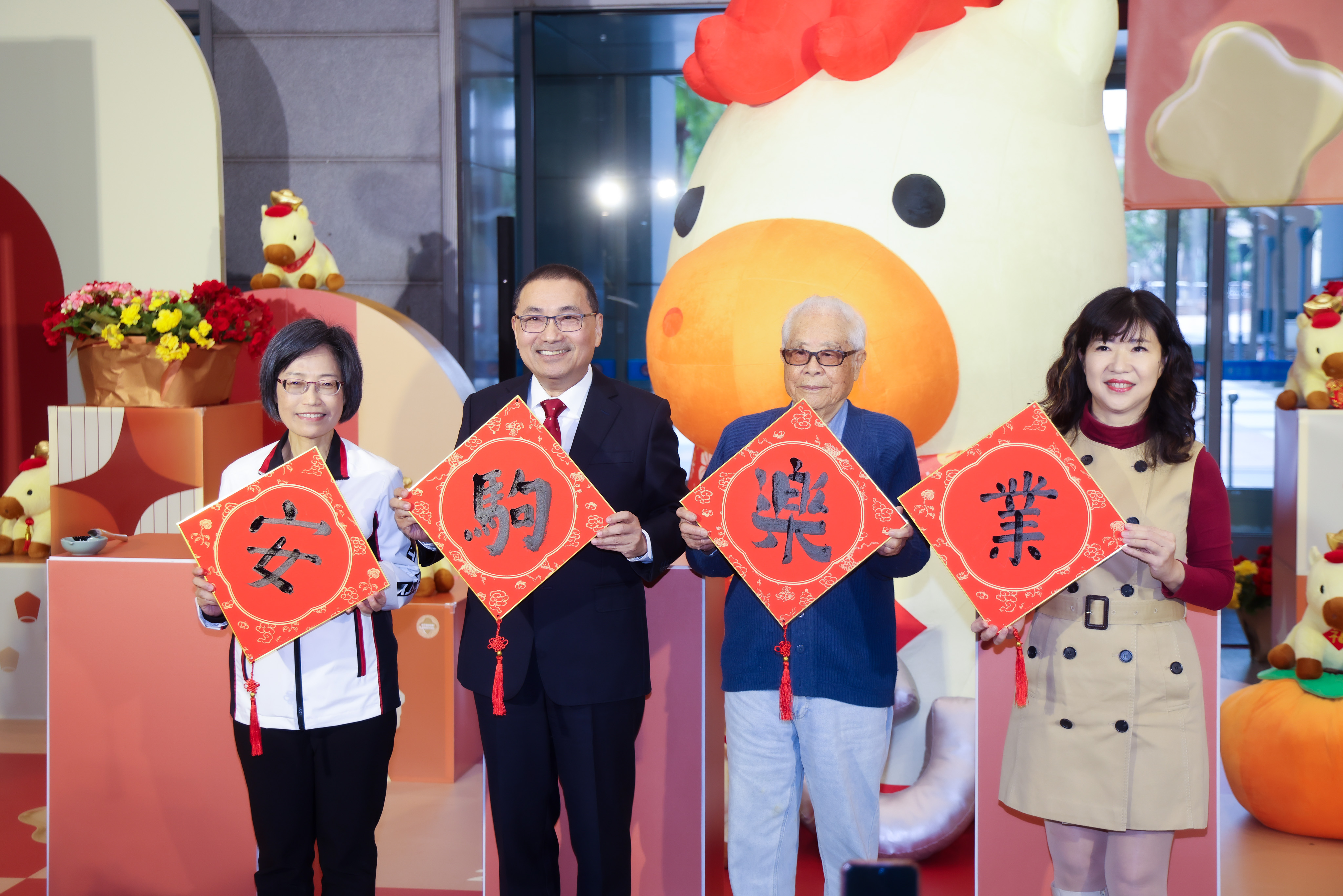 侯友宜與百歲人瑞沈軏及秘書處長祝惠美、經發局長盛筱蓉一同揮毫「安駒樂業」四字，期許市政順利推進如駿馬奔馳，市民安居新北。