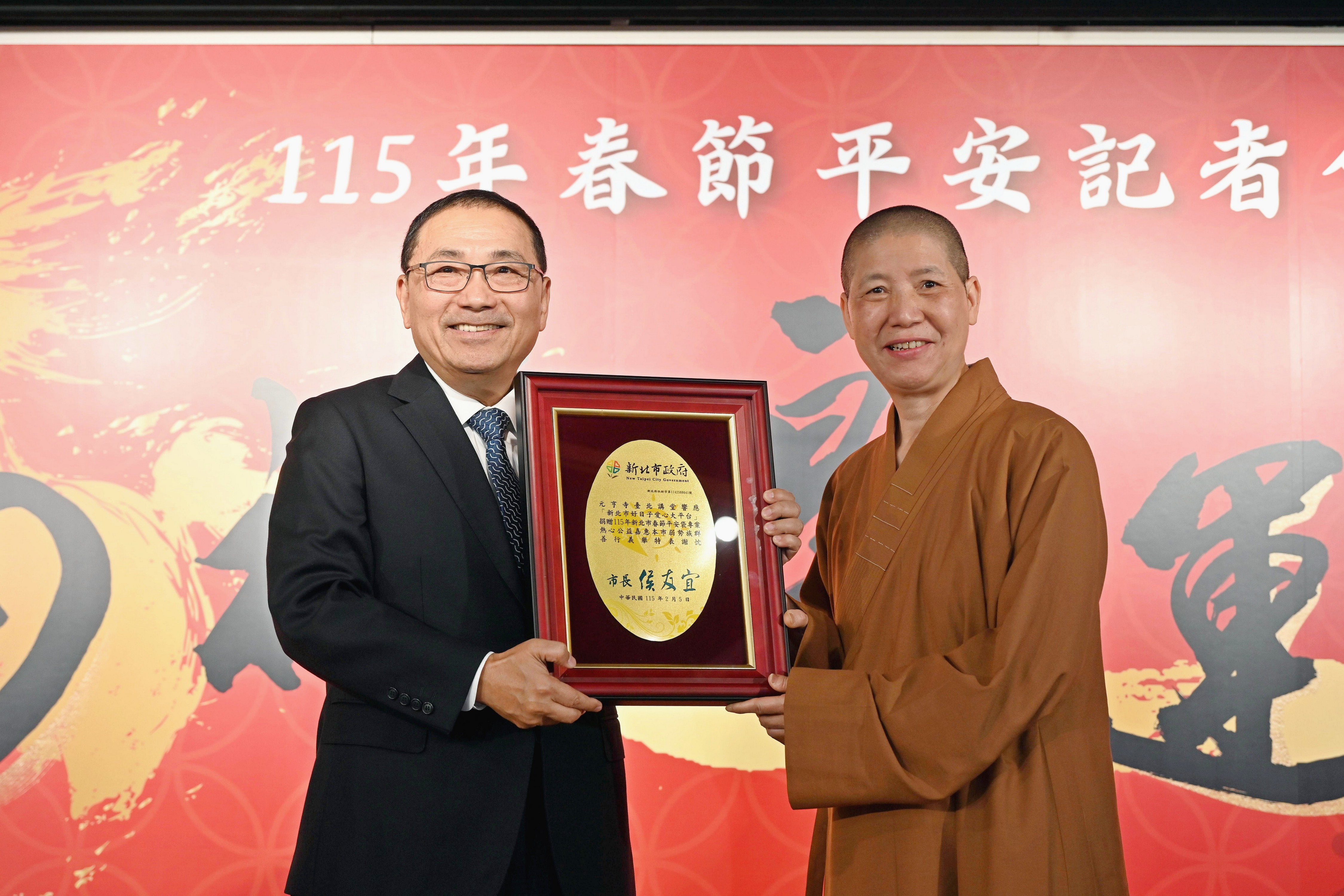 侯友宜致贈感謝狀，感謝元亨寺臺北講堂、新莊慈祐宮、手信坊股份有限公司捐助平安袋物資。右為元亨寺台北講堂釋蓮心法師